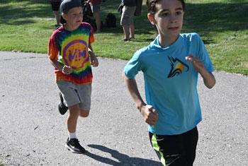 Boys running at Miles 4 Mentors Fun Run Event Give Sponsors Volunteers Participants